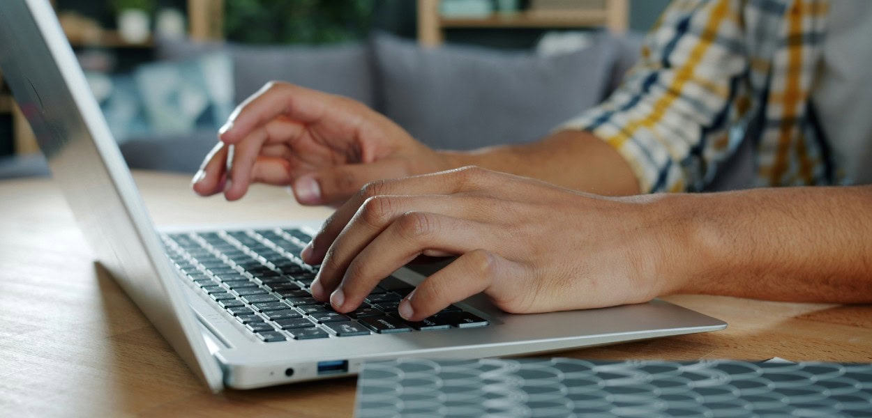 manos de chico tecleando en computadora