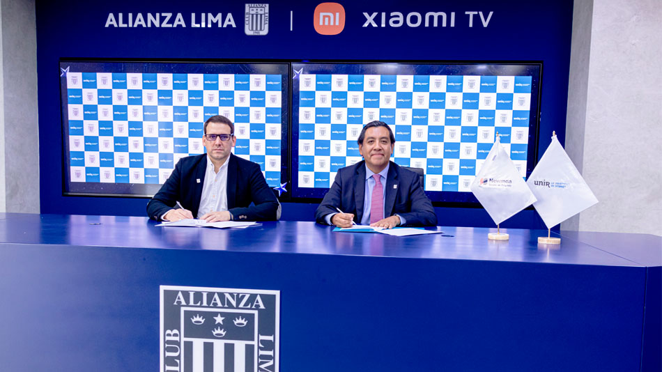 A la izquierda, Nicolás Rey gerente de Relaciones Públicas e Imagen Institucional del club de fútbol Alianza Lima, y Martín Santivañez, country manager de UNIR Perú, firman el acuerdo entre las dos instituciones. 