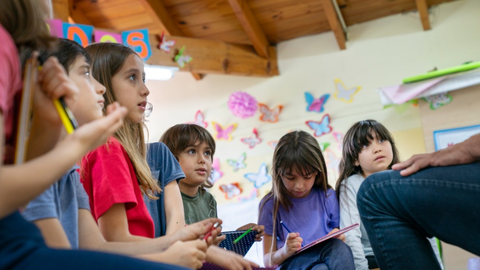 Niños de primaria escuchando a un psicopedagogo