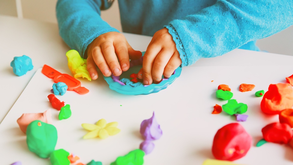 Niño jugando con plastilina para estimular su psicomotricidad