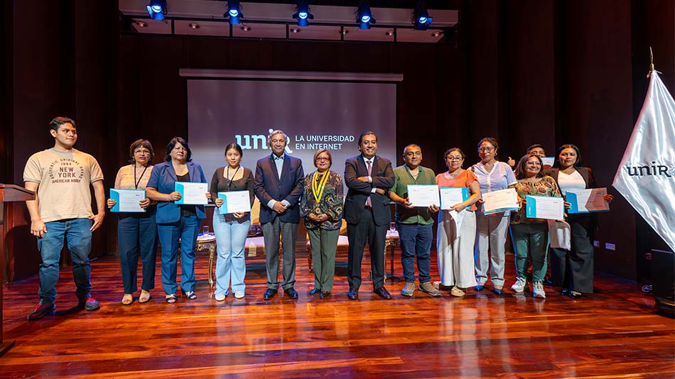 Los representantes de LA MML y UNIR rodeados por algunos beneficiados con las becas.